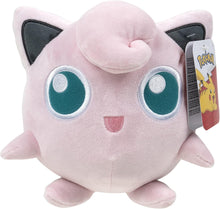 Plush toy Jigglypuff creature with large blue eyes and a tag on a white background