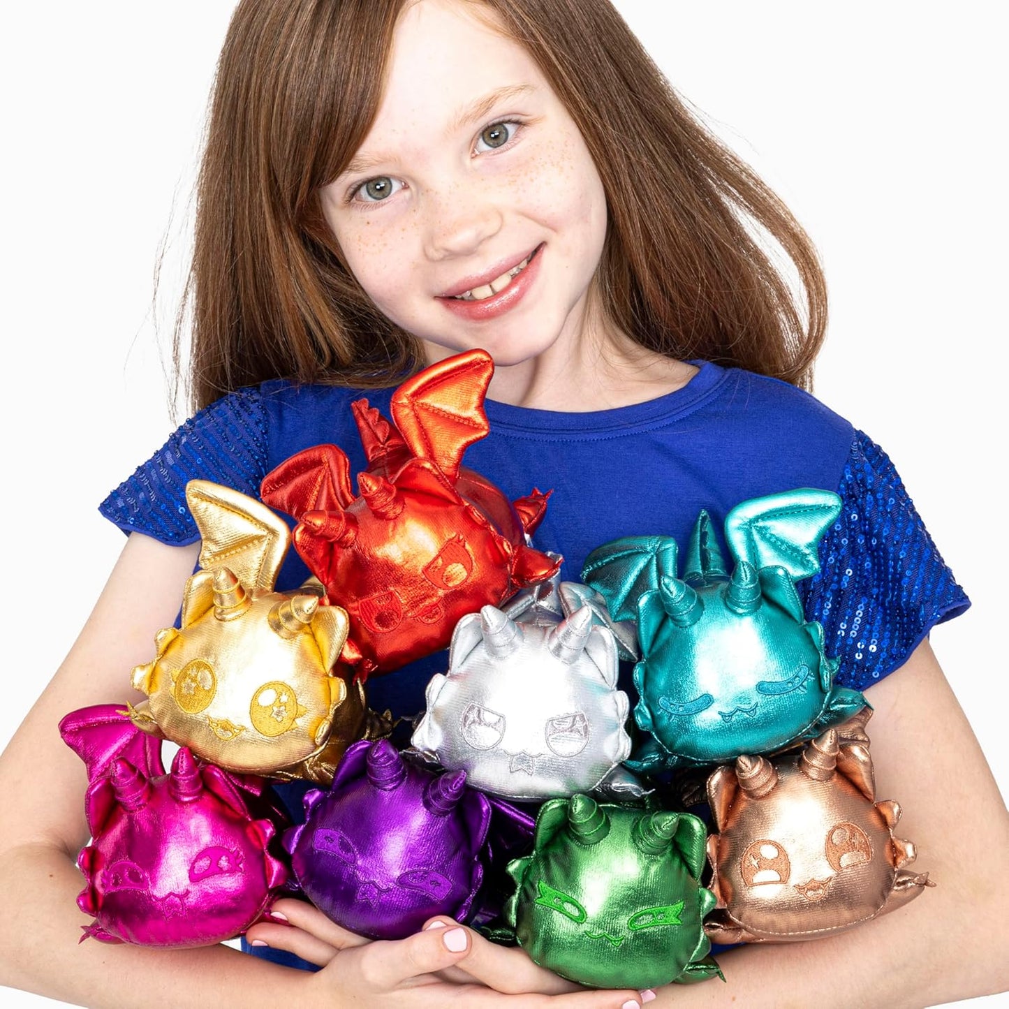 Girl holding colorful dragon-shaped toys against a white background