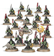 Collection of miniature witch figurines with green faces and various accessories on a white background