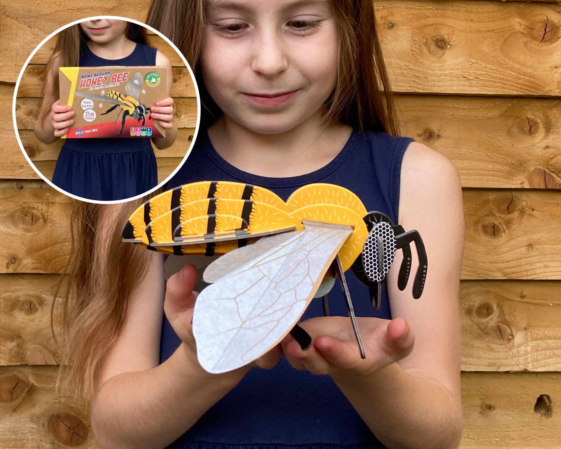 Girl holding a paper wasp model with inset showing a book titled 'Wasp'.