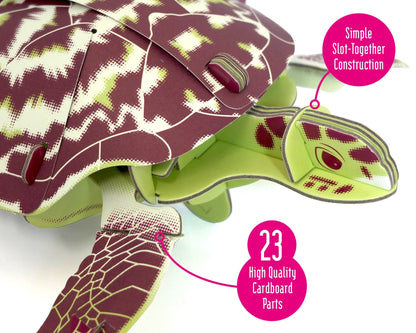 Cardboard turtle model with green and purple pattern on a white background