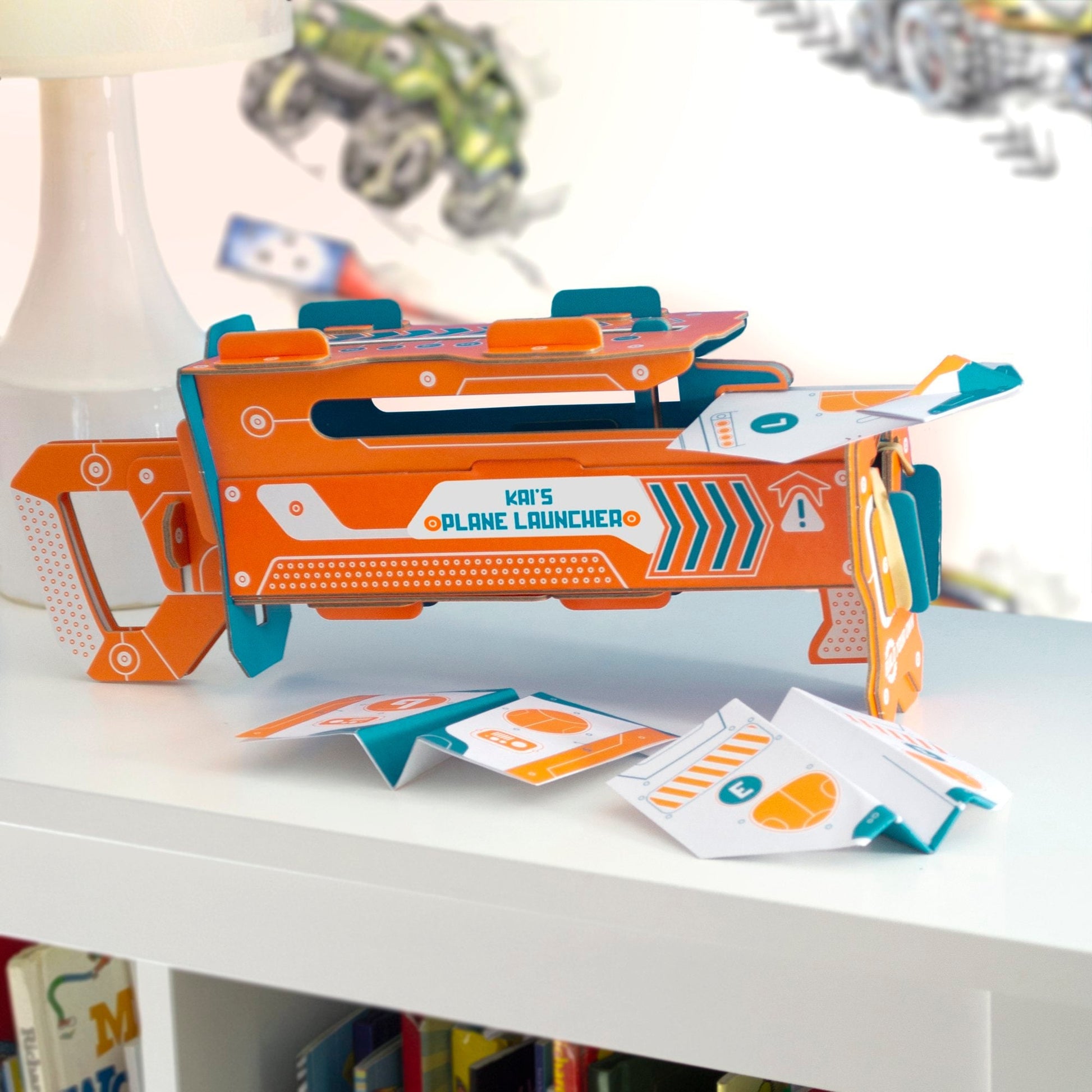 Toy plane launcher with cards on a white surface