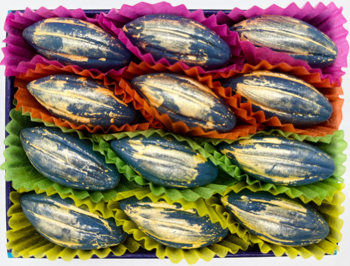 Box of chocolates with colourful paper liners on a white background