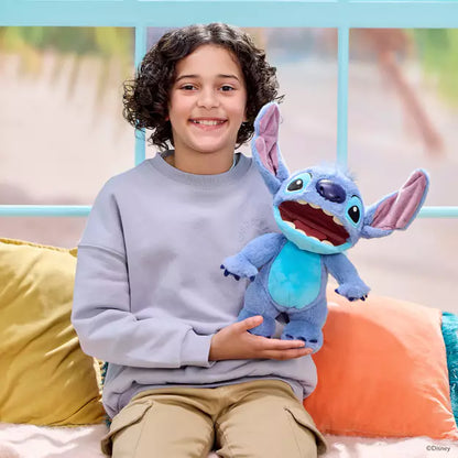 Child holding a large blue plush toy resembling a character from Disney, sitting on a colorful couch.