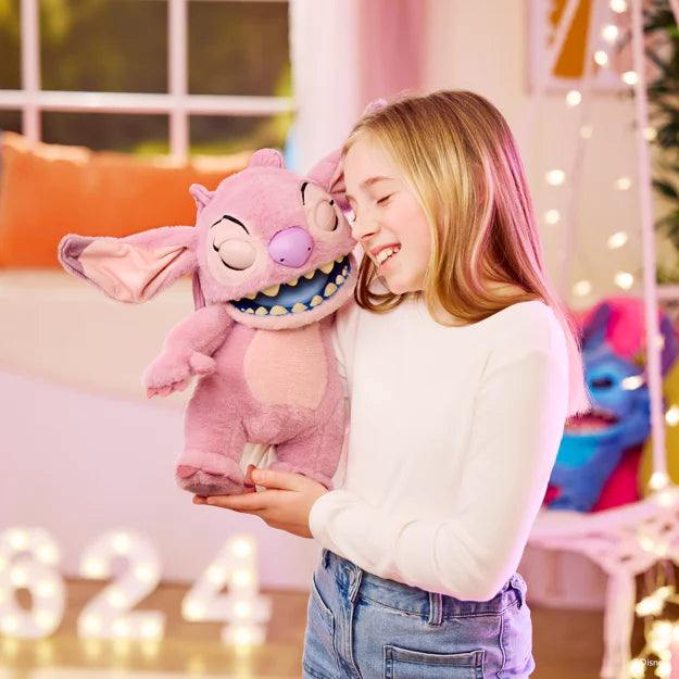 Young girl holding a pink plush toy with a smiling expression in a festive indoor setting.