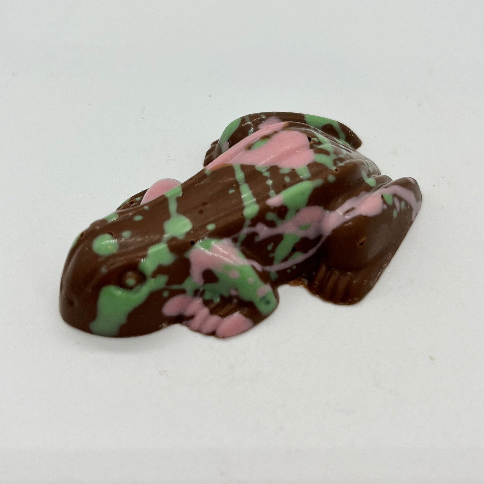 Chocolate frog with green and pink patterns on a white background