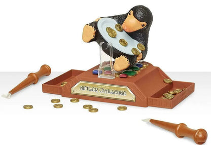 Toy figure of a character from 'Harry Potter' with a platform labeled 'Muggle Challenge', surrounded by coins and a wand.