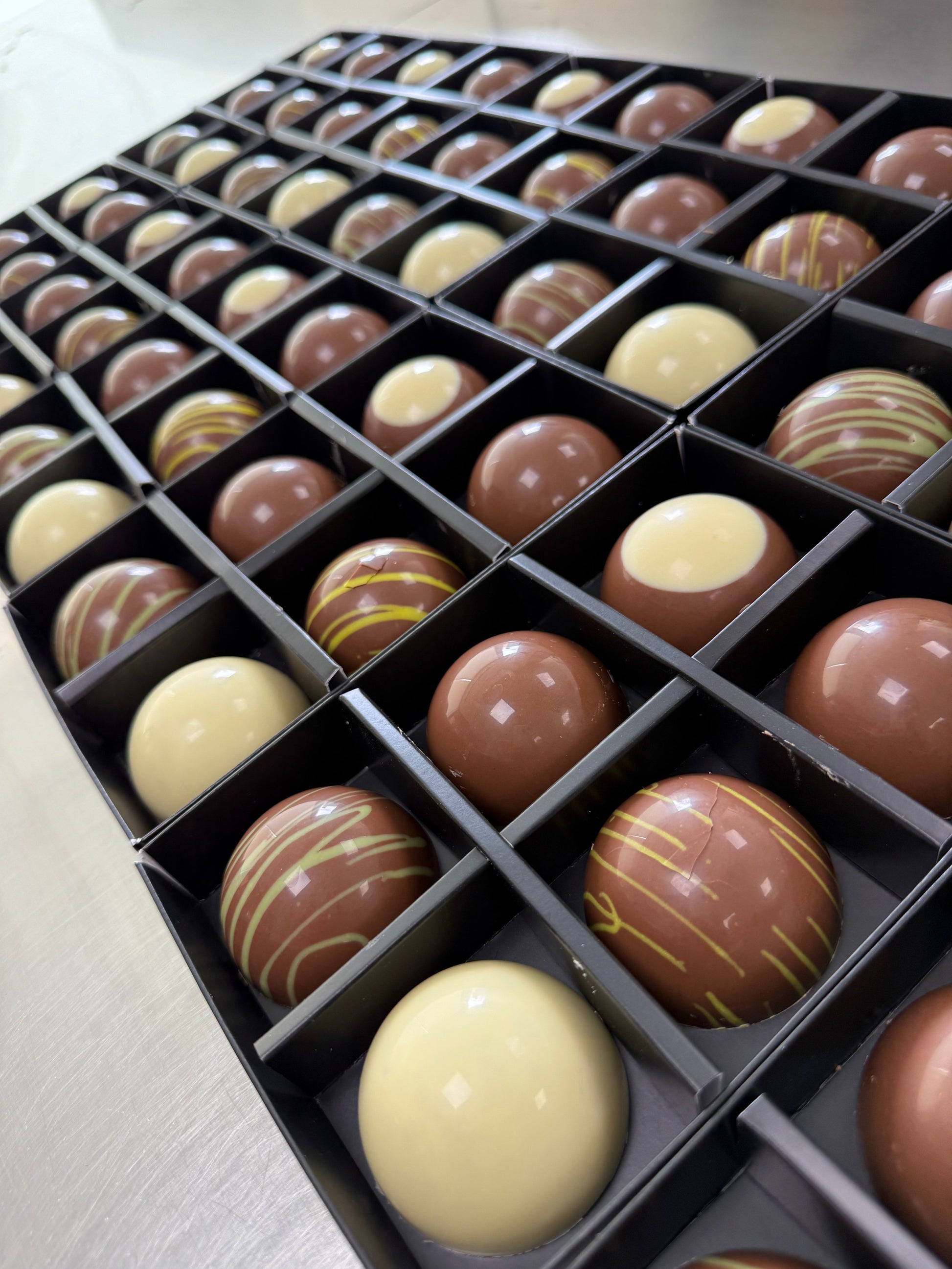Assorted chocolates in a box on a light background