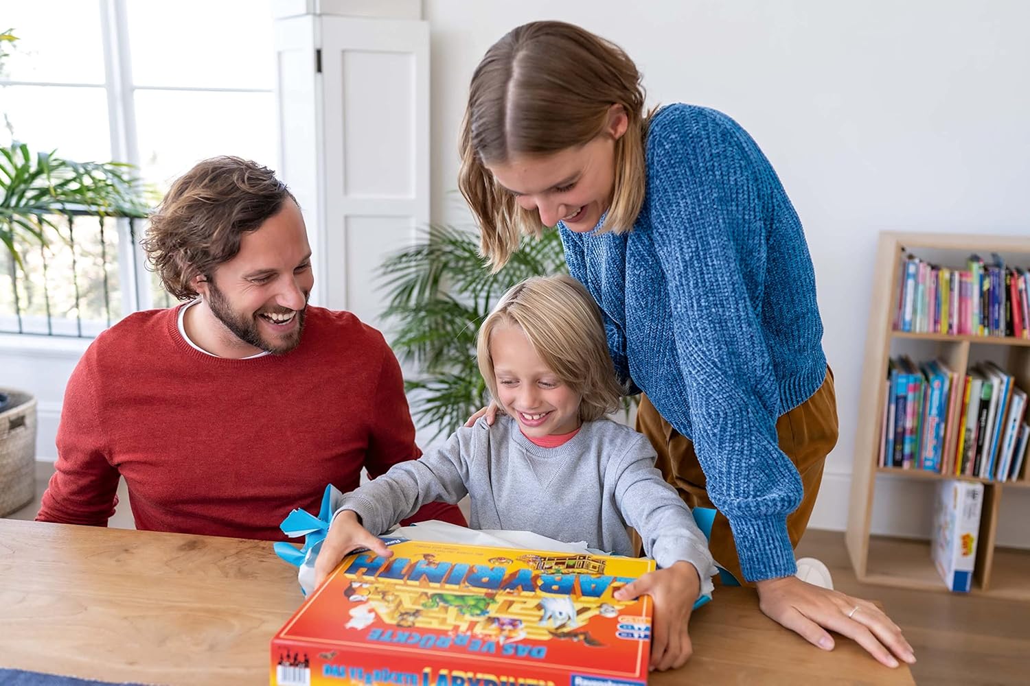 Family playing a board game together in a cozy living room.