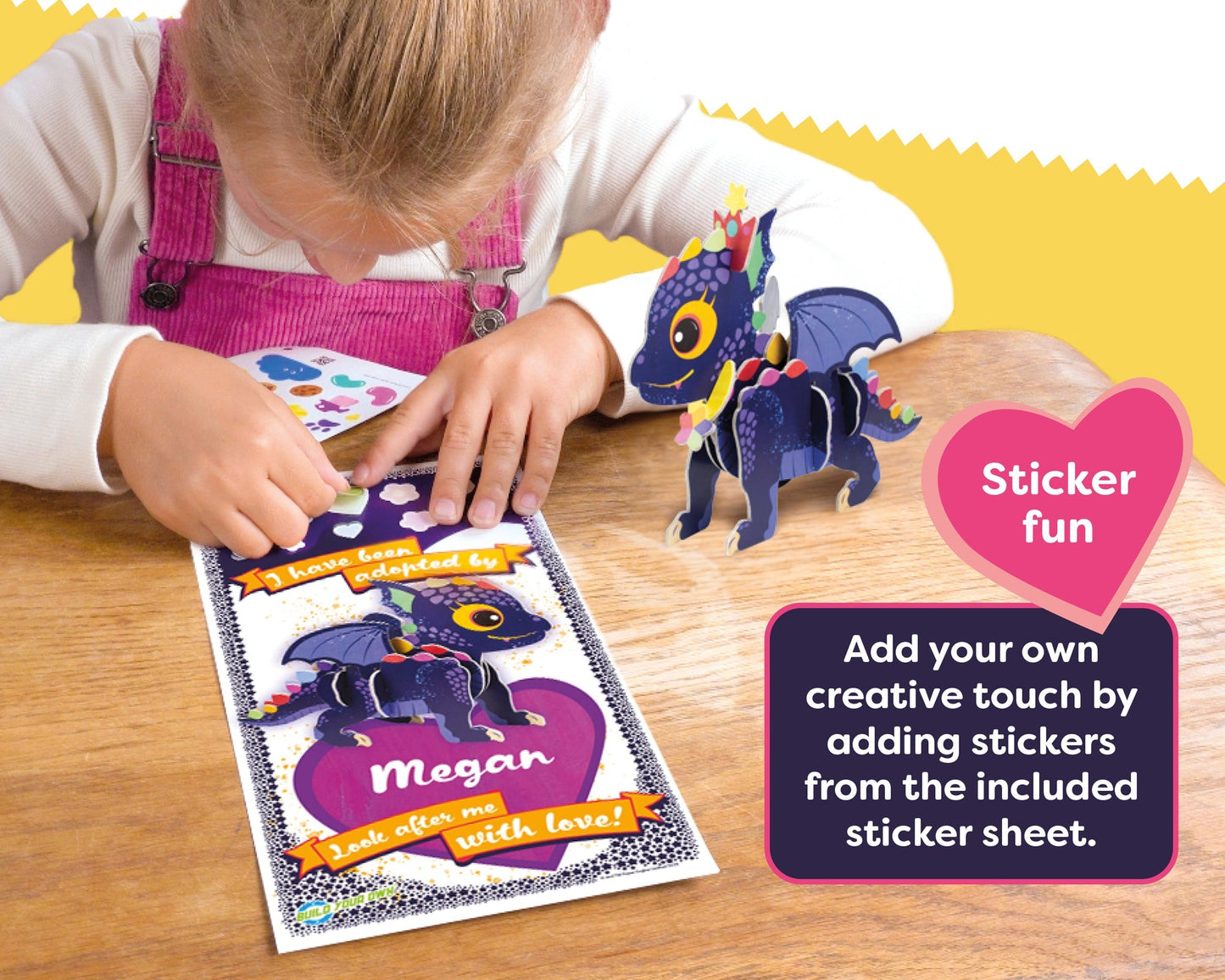 Child interacting with a craft activity set on a wooden table, featuring a dragon design and text about sticker fun.