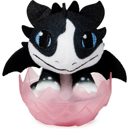 Plush toy with black and white design in a pink egg on a white background
