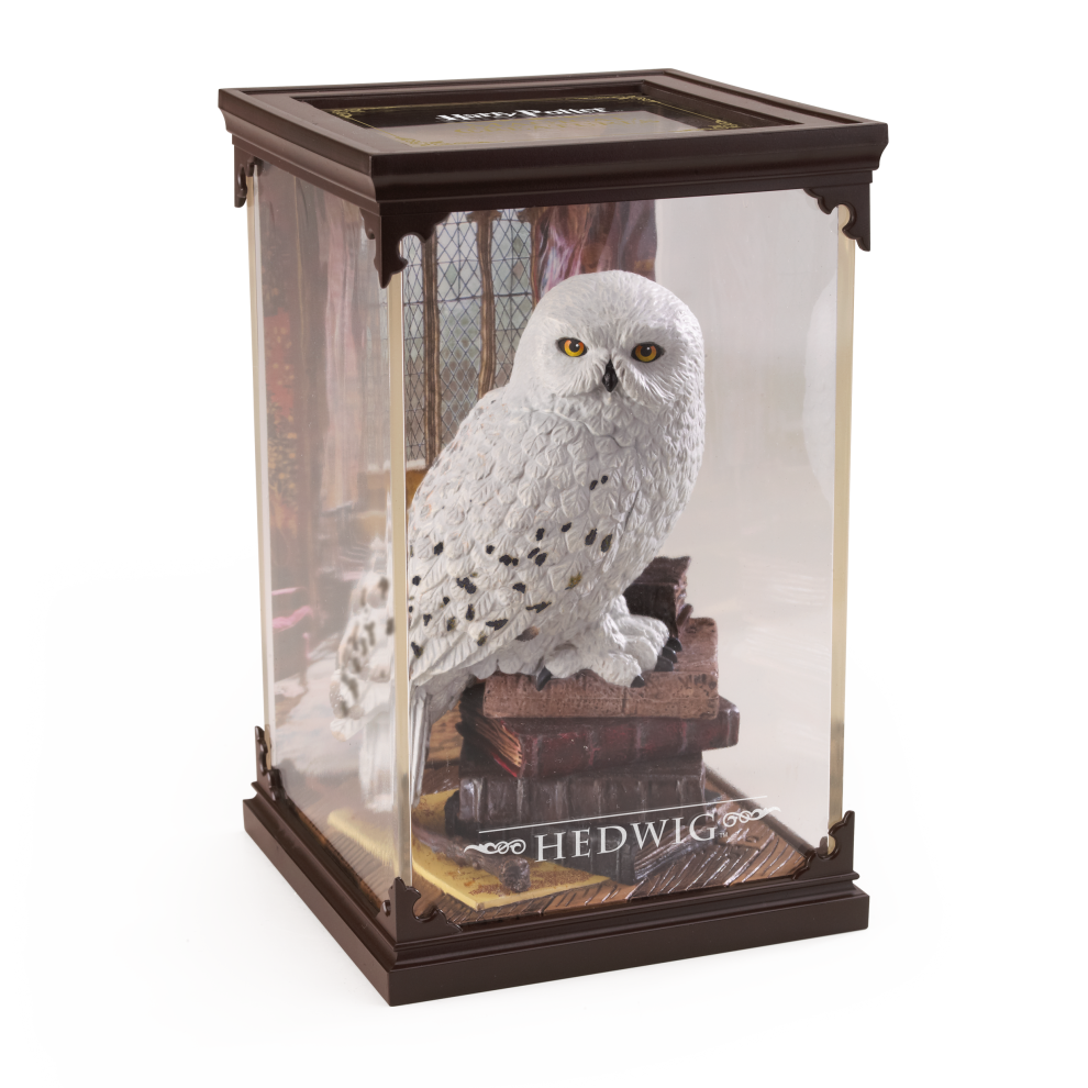 Model of a snowy owl in a glass display case with 'Hedwig' branding.
