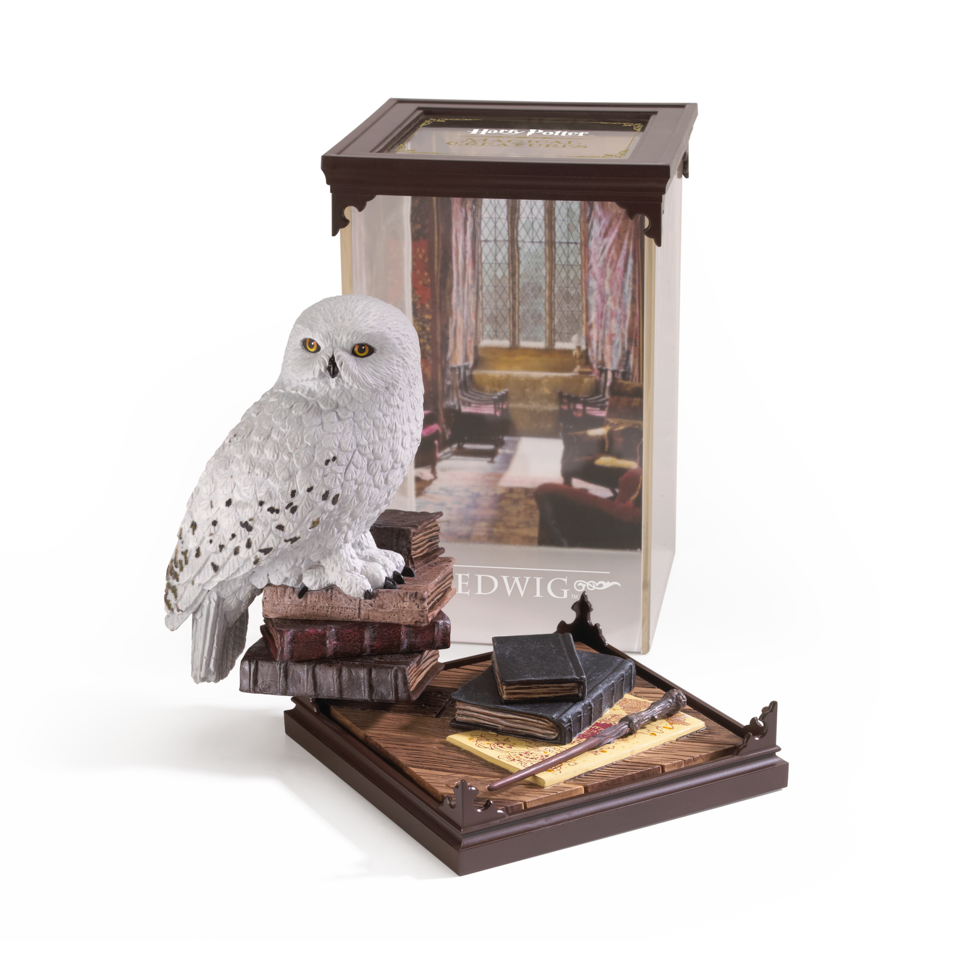 Model of a snowy owl Hedwig on books with a Harry Potter-themed box in the background