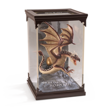 Model of a Hungarian Horntail dragon in a display case with 'Harry Potter' branding.