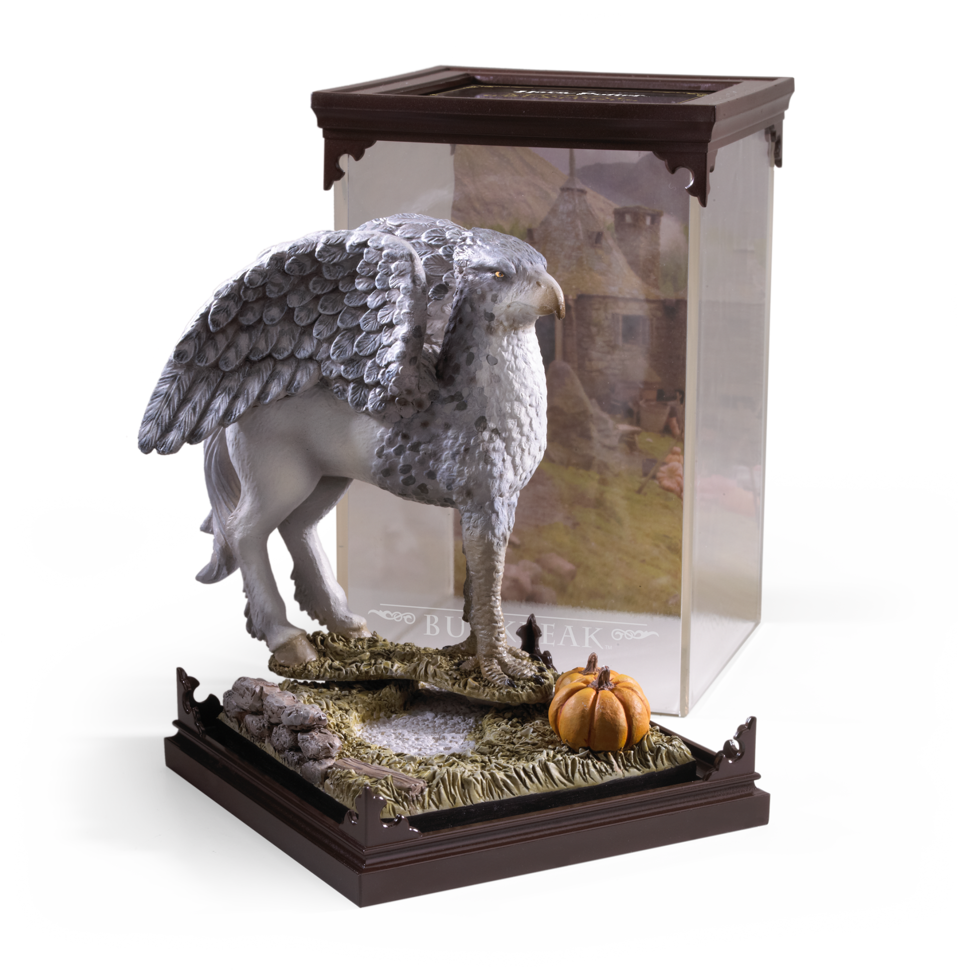 Statue of a winged creature Buckbeak on a decorative base with a clear display case.