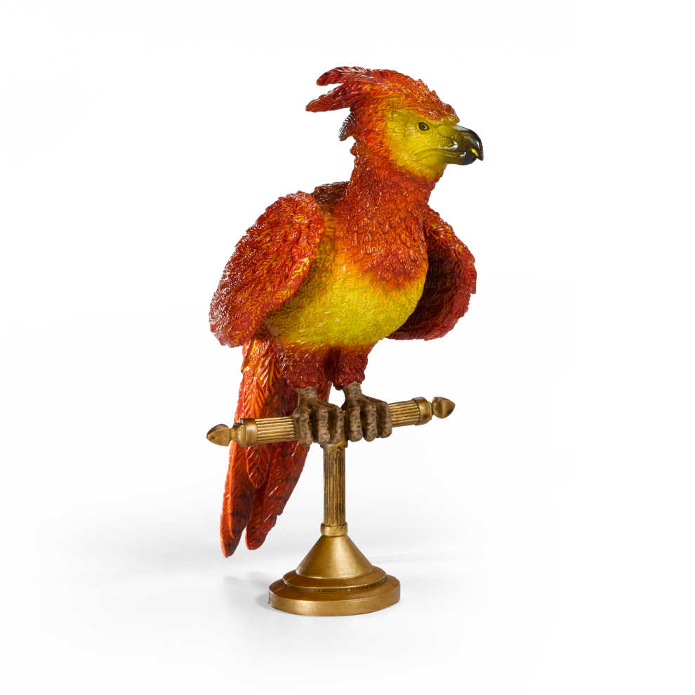 Colorful Fawkes figurine on a stand against a white background