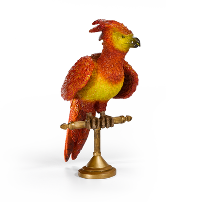 Colorful Fawkes figurine on a stand against a white background