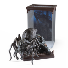 Detailed Aragog figurine in front of a glass display case with a dark interior.