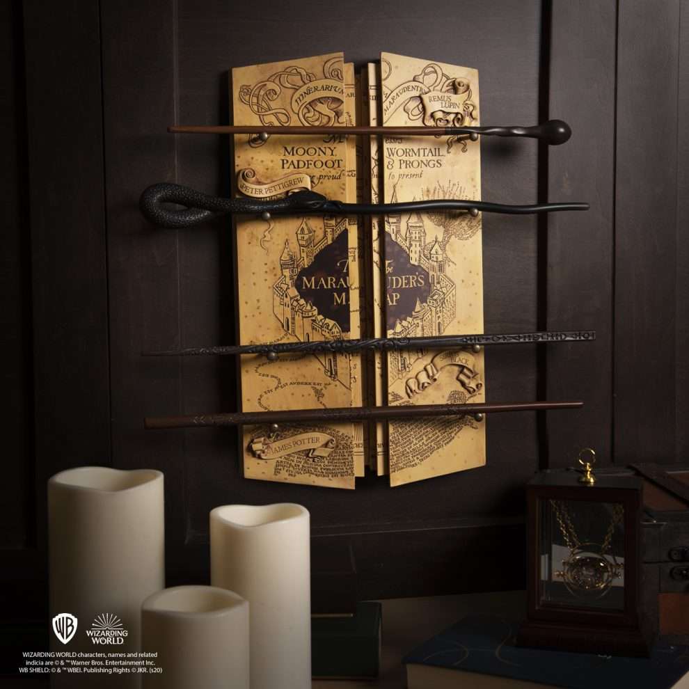 Four wizarding wands displayed against a book with 'Harry Potter' design, featuring the Warner Bros. logo.