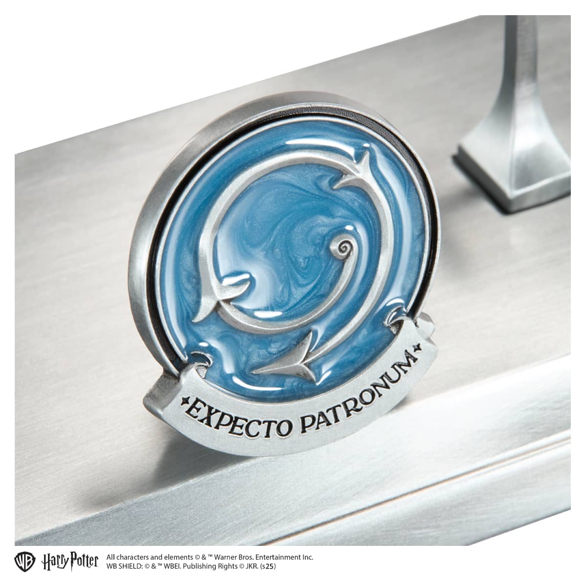Decorative emblem with 'EXPECTO PATRONUM' text on a metallic surface, featuring the Harry Potter brand.