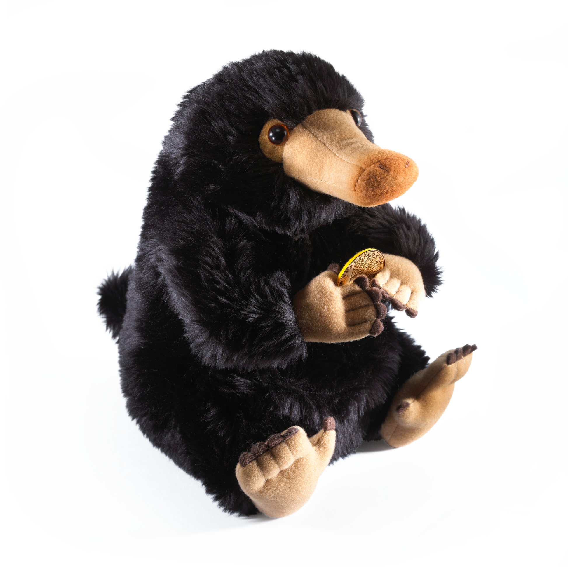 Plush toy Niffler holding a yellow flower on a white background
