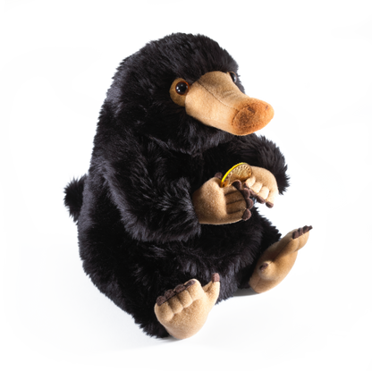 Plush toy Niffler holding a yellow flower on a white background