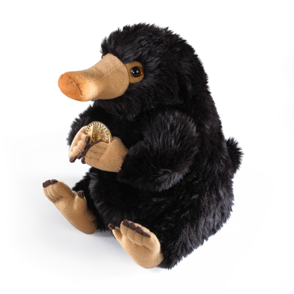 Plush Niffler holding a gold coin on a white background
