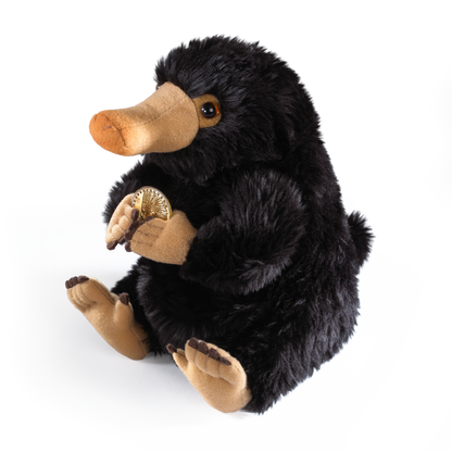 Plush Niffler holding a gold coin on a white background