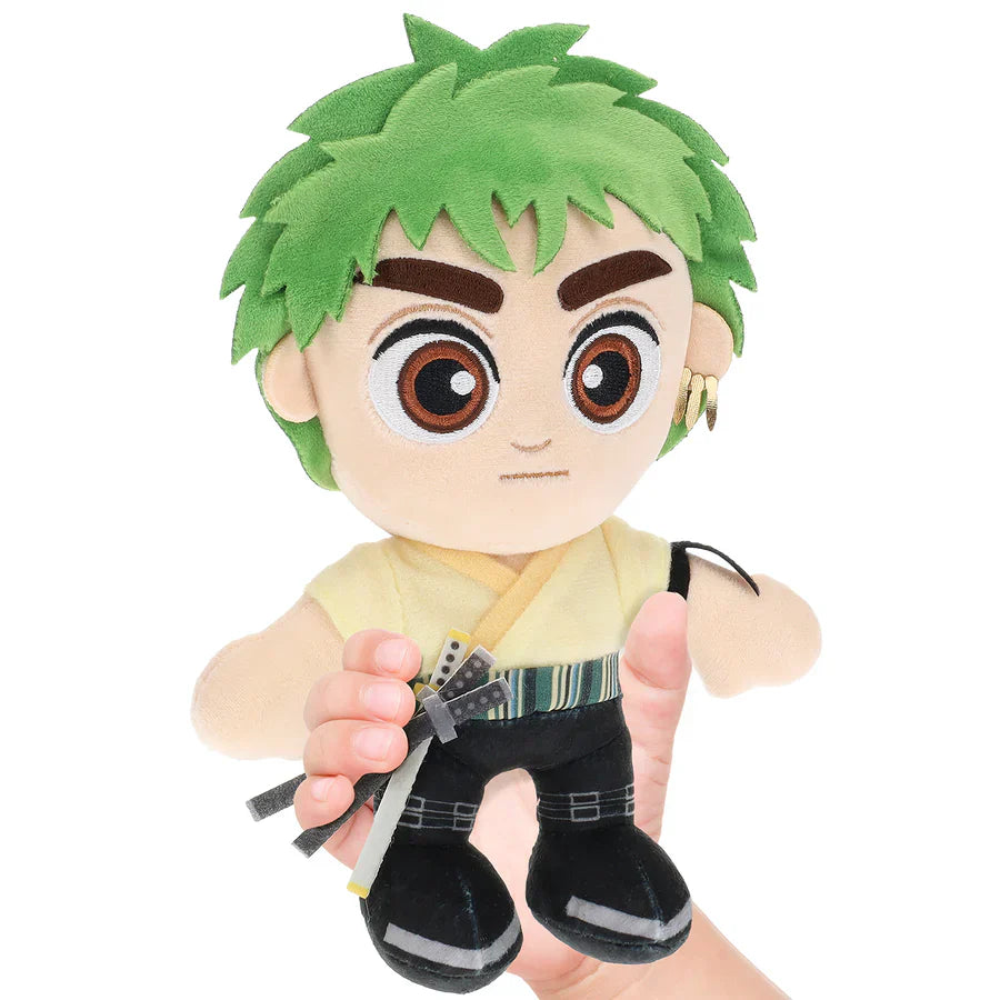 Plush toy of an animated character with green hair and a sword, held in a hand against a white background.