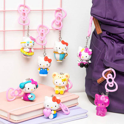 Colorful Hello Kitty keychains on a pink grid background with a purple jacket.