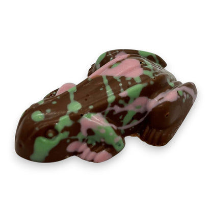 Chocolate candy shaped like a fish with green and pink patterns on a white background