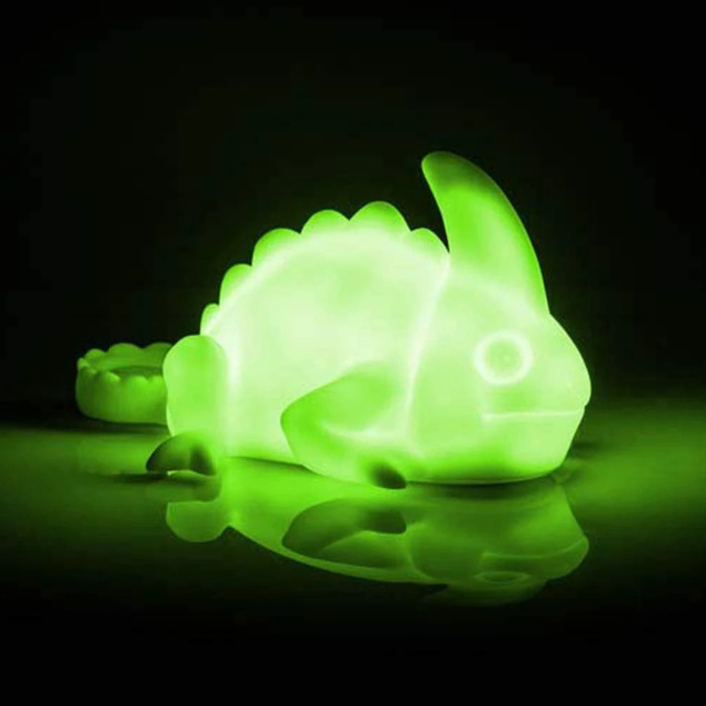 Green dinosaur-shaped night light on a dark background