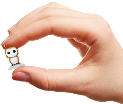 Hand holding a small owl figurine against a white background