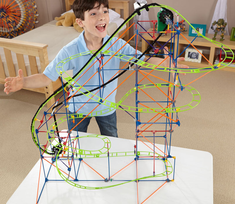 Child playing with a colorful marble run toy set in a room.