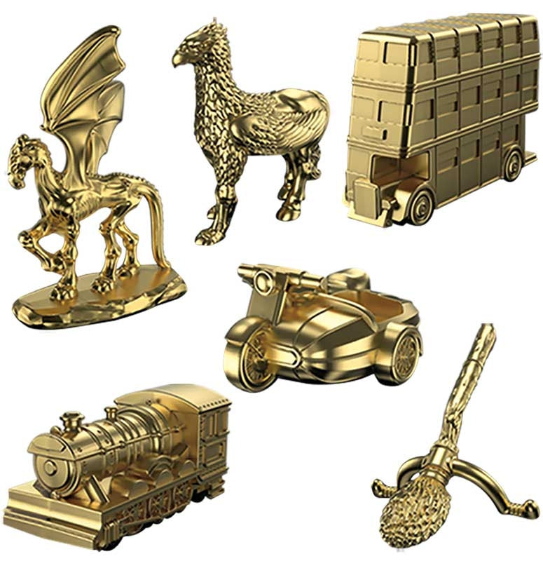 Collection of gold figurines including a dragon, rooster, bus, car, train, and broom on a white background.