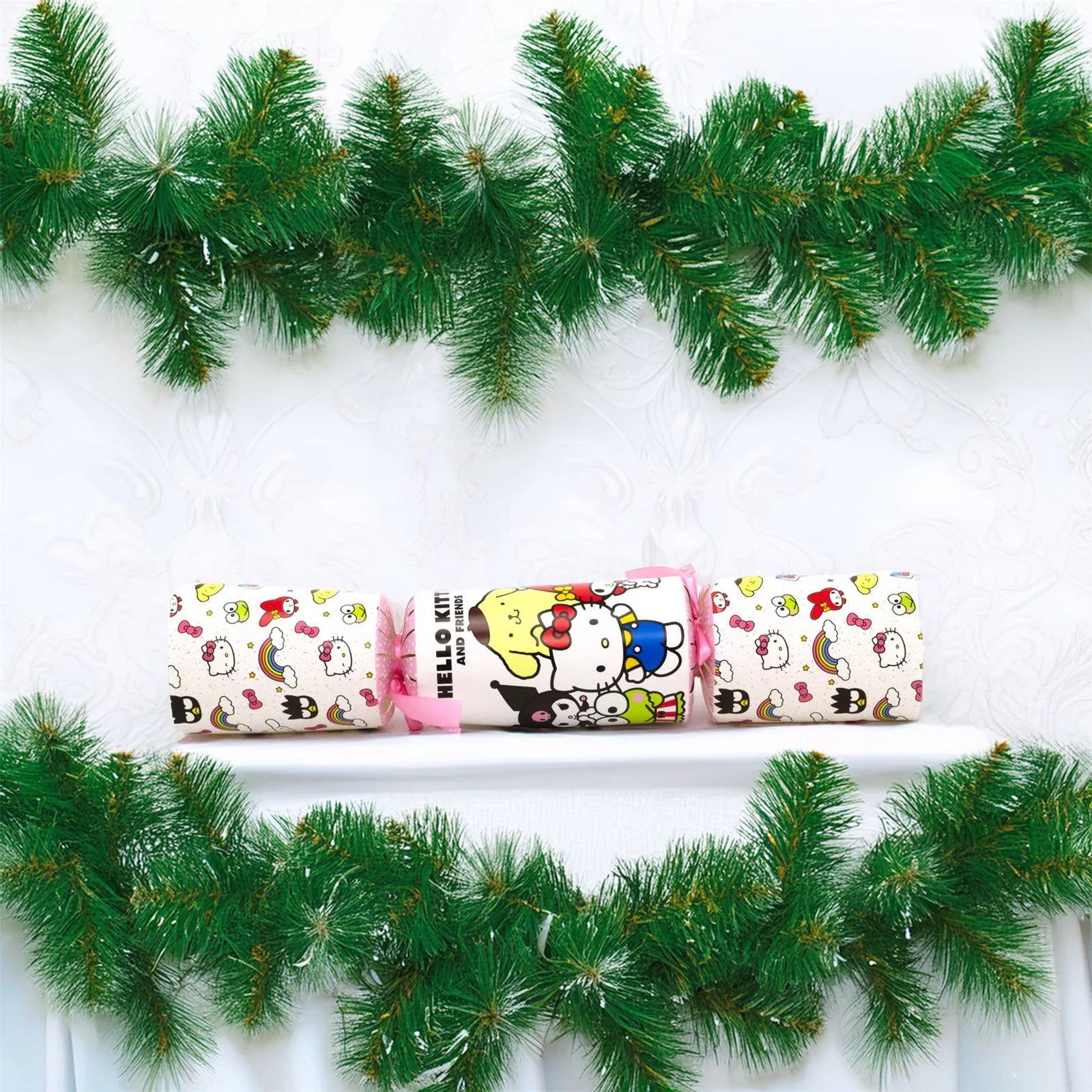Decorative Christmas cracker with Hello Kitty design on a white background with green garland.