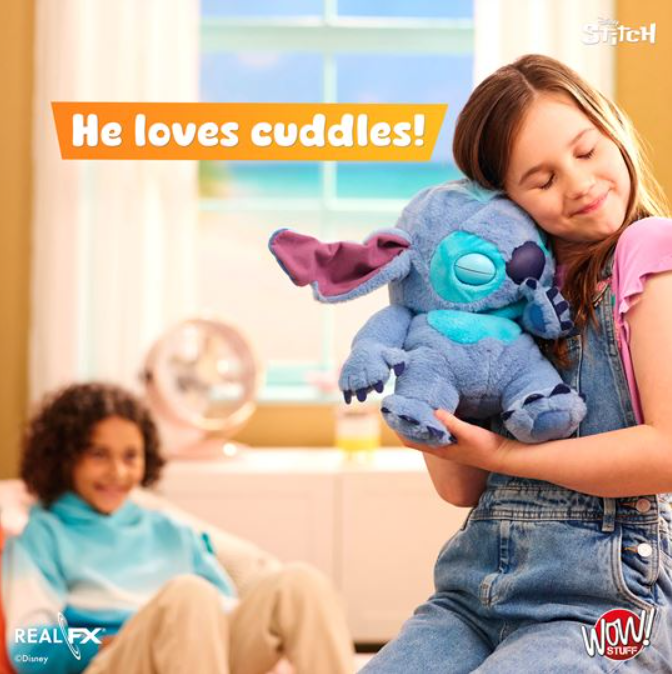 Child holding a blue plush toy with 'He loves cuddles!' text and a girl in the background.
