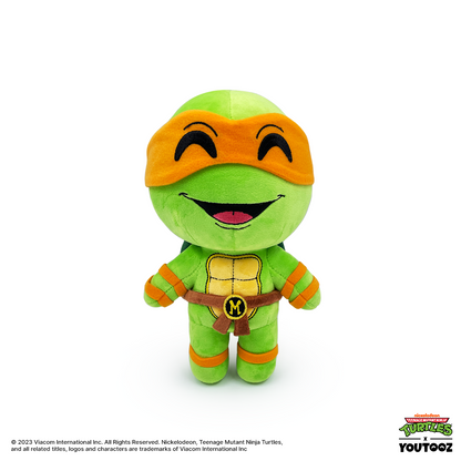 Plush toy of a green turtle character with orange mask and belt on a white background