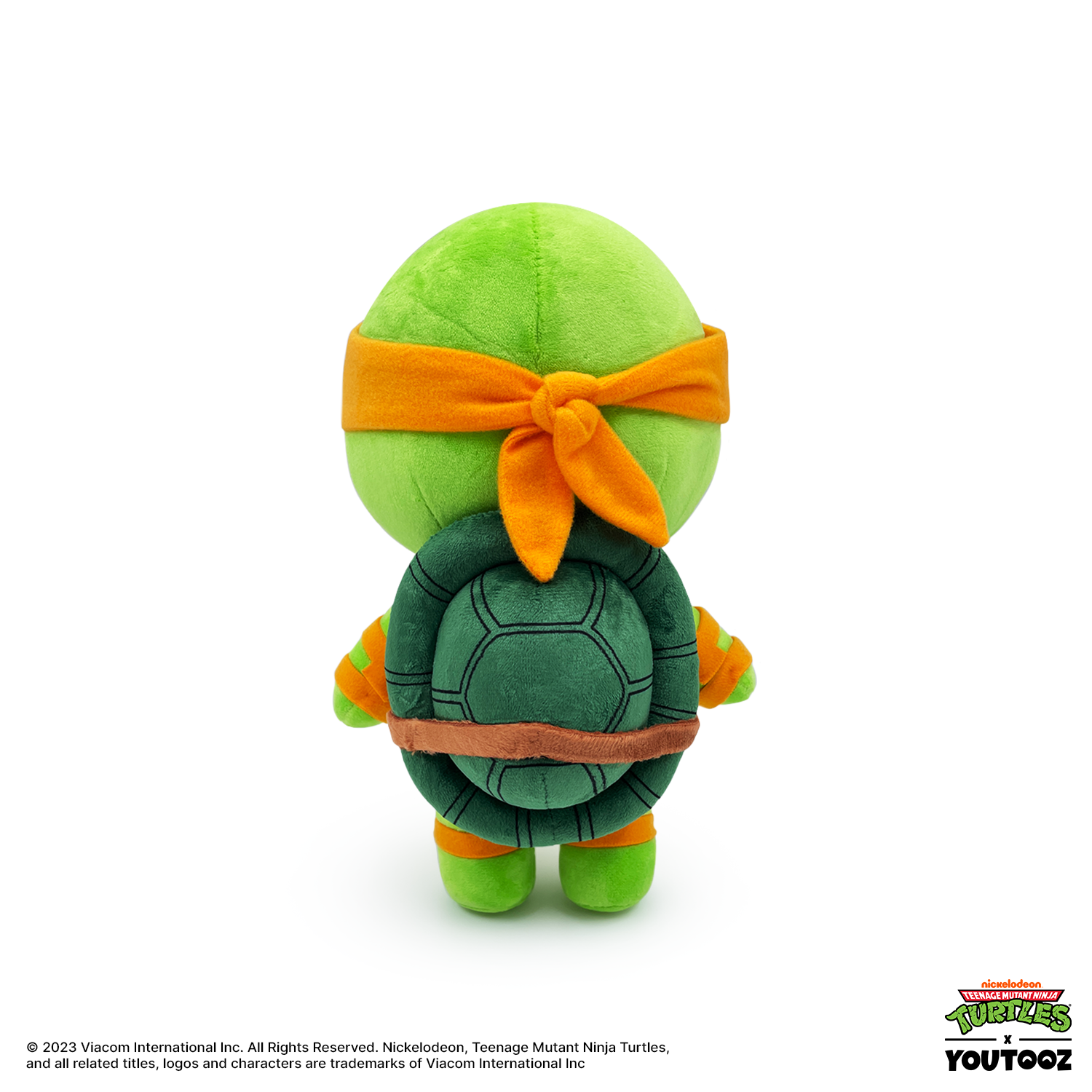 Plush toy of a green turtle with an orange headband on a white background