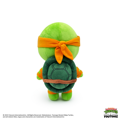Plush toy of a green turtle with an orange headband on a white background