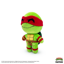 Plush toy of a green turtle character with red mask on a white background
