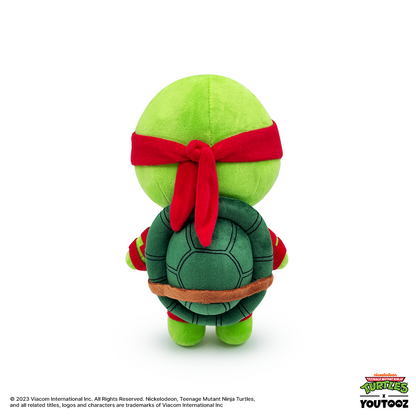 Plush toy of a green turtle with a red bandana on a white background